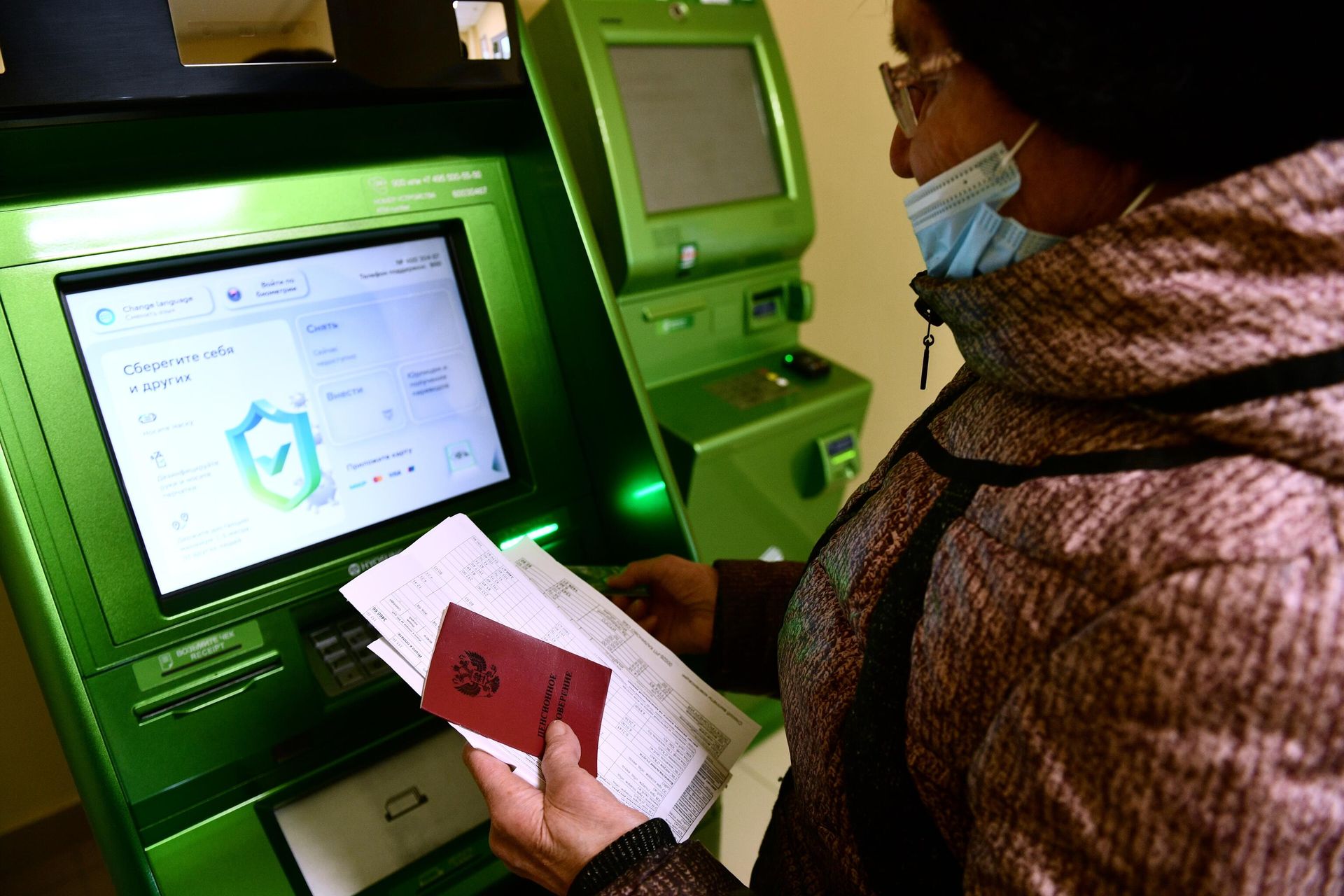 Выплаты пенсионерам к Новому году и после: что изменится в 2026 году Женщина возле банкомата - РИА Новости, 1920, 22.12.2021